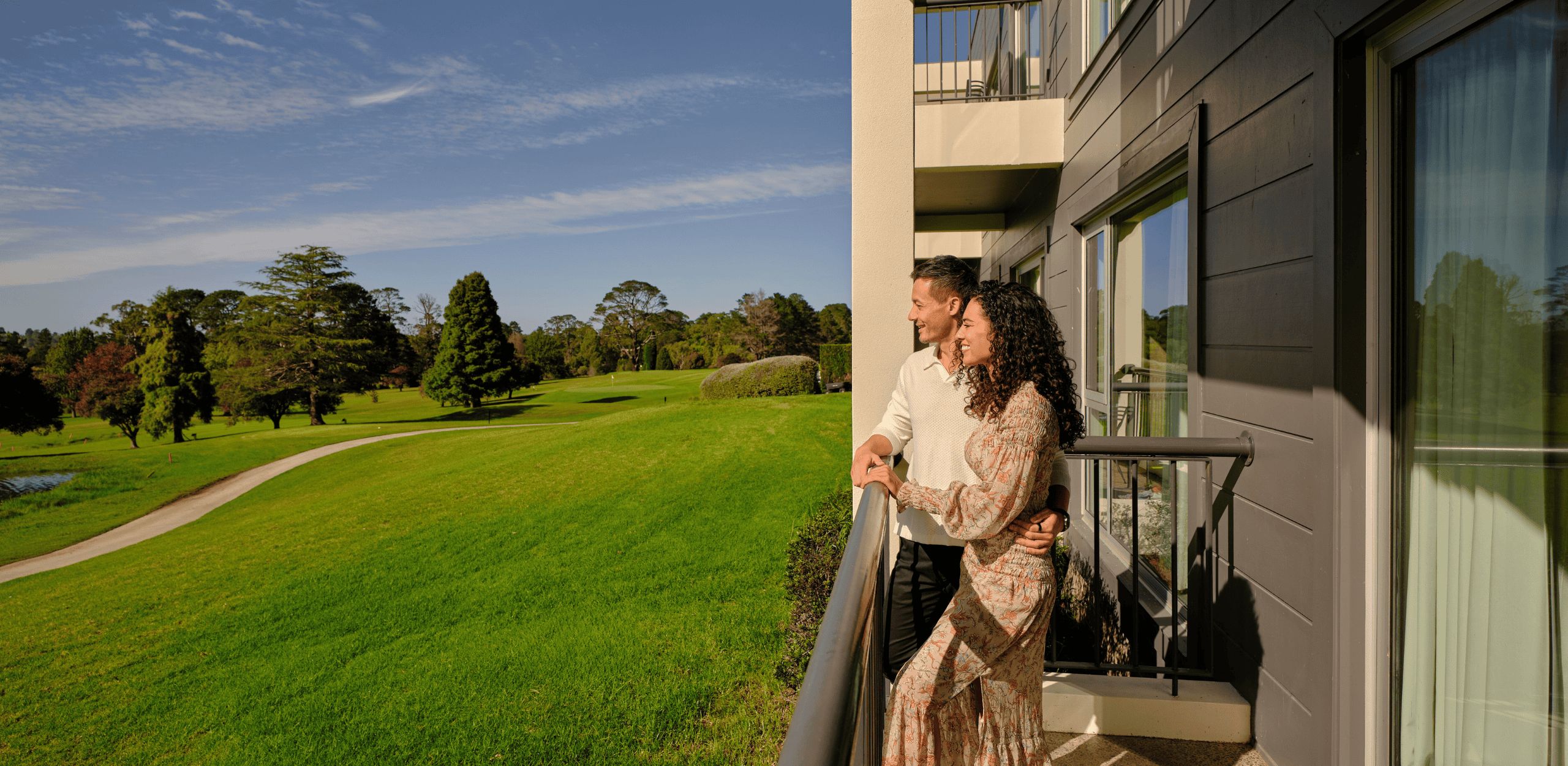 Couple looking over room balcony at Park Proxi Bowral.