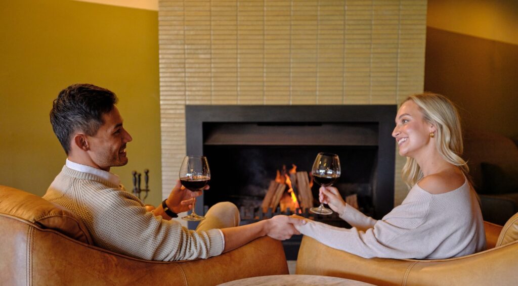 Couple sitting in front of fireplace in Harveys Bar, Bowral