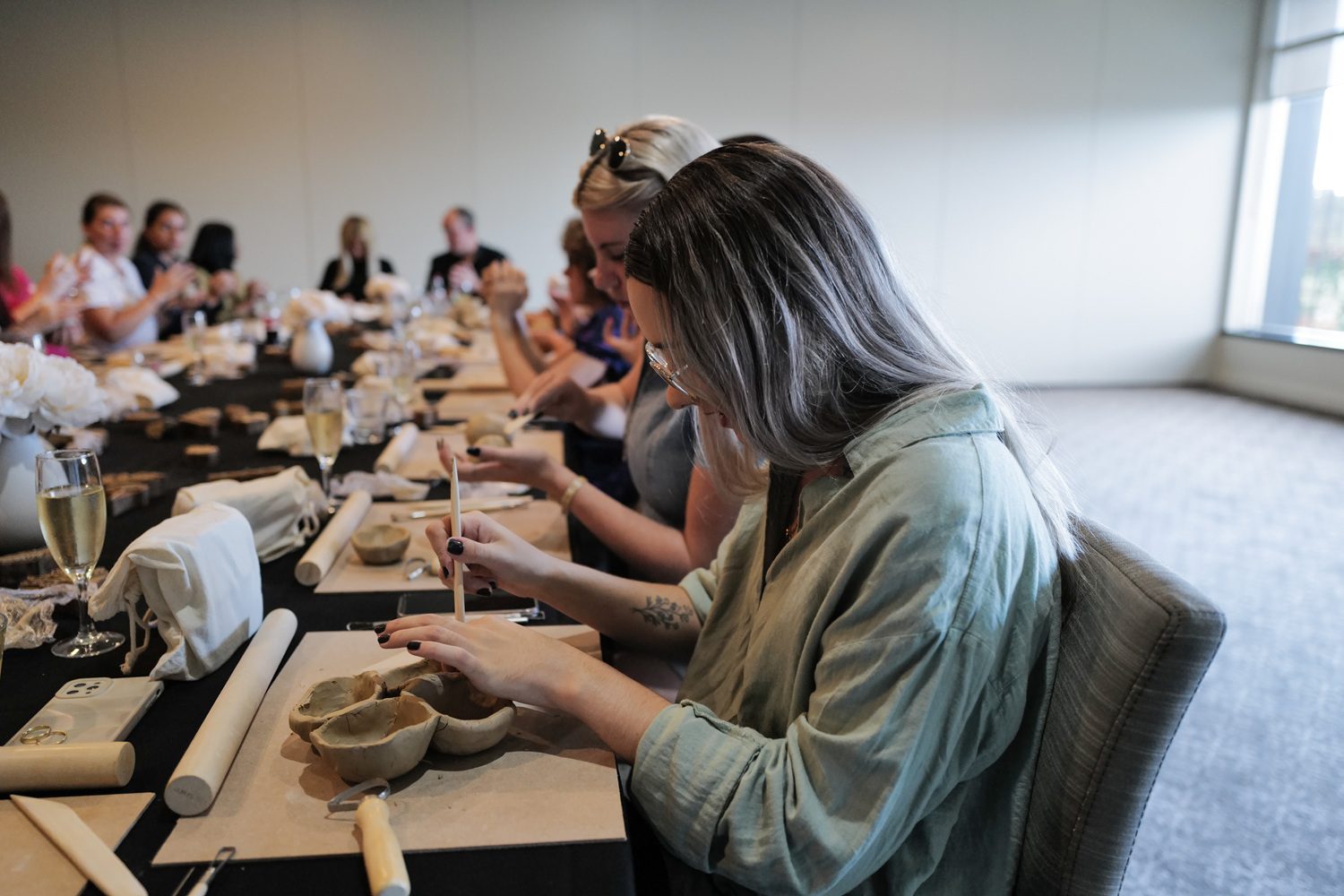 Young lady playing with clay during team building activity at Park Proxi Bowral